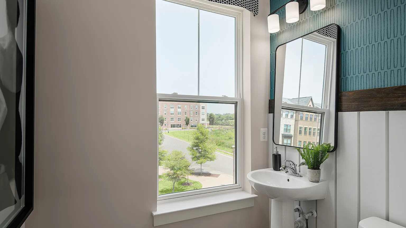 The Kincora Residence — Powder room with pedestal sink and framed mirror at The Kincora Residence model home