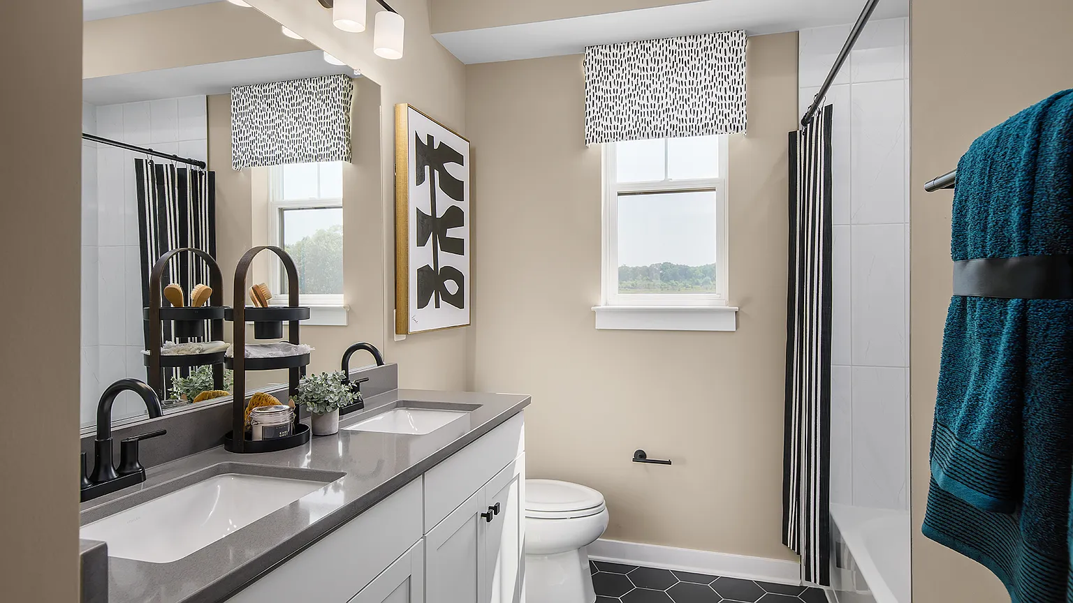 Shared full bath with dual sink vanity and tub-shower at The Kincora Residence model home
