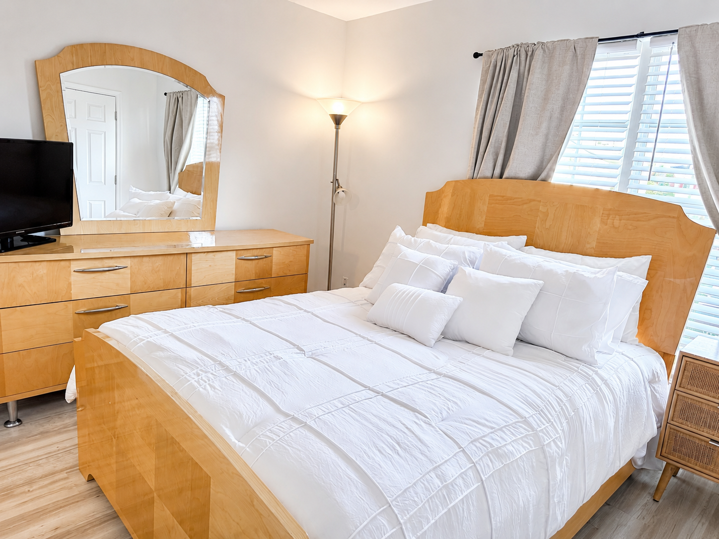 The Ashburn Residence — Second bedroom with white linens, dresser, and natural light