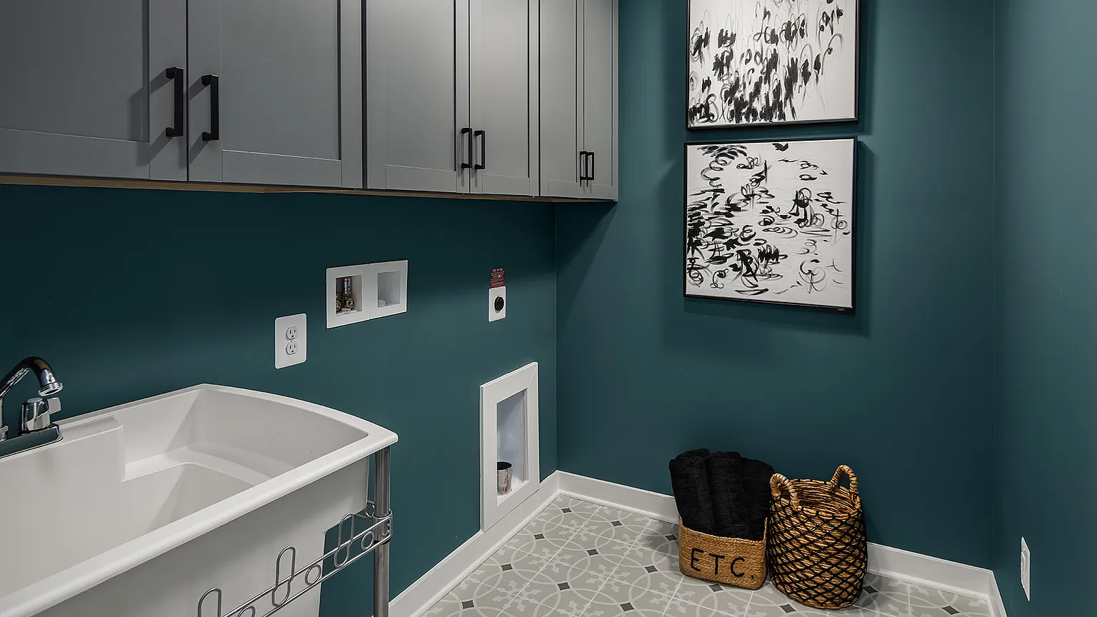 The Kincora Residence — Laundry room with utility sink, upper cabinets, and patterned tile floor at The Kincora Residence model home