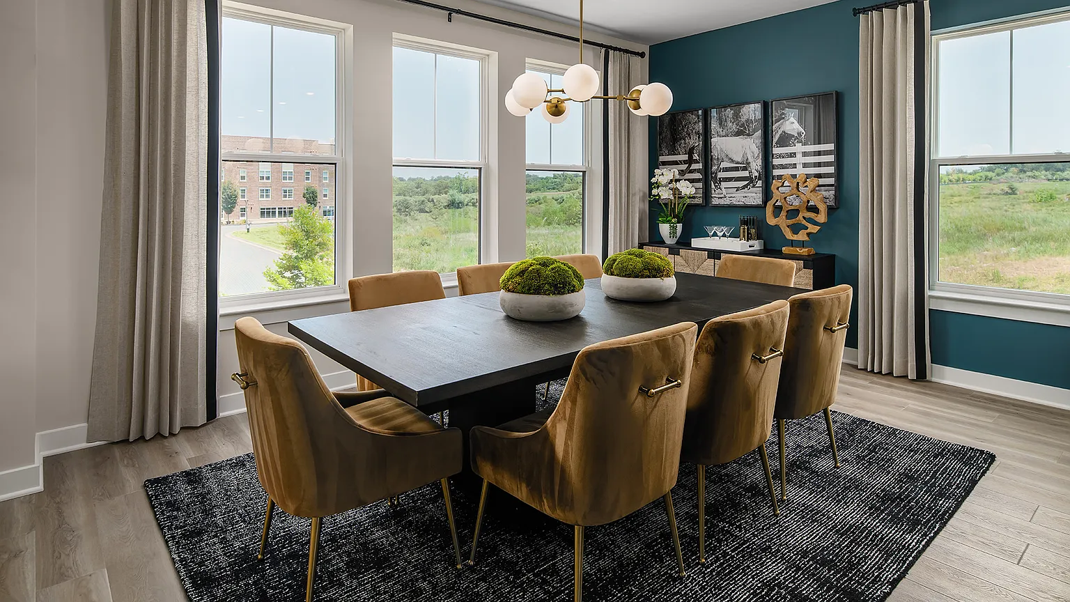 Dining room with large windows, chandelier, and seating for eight at The Kincora Residence model home