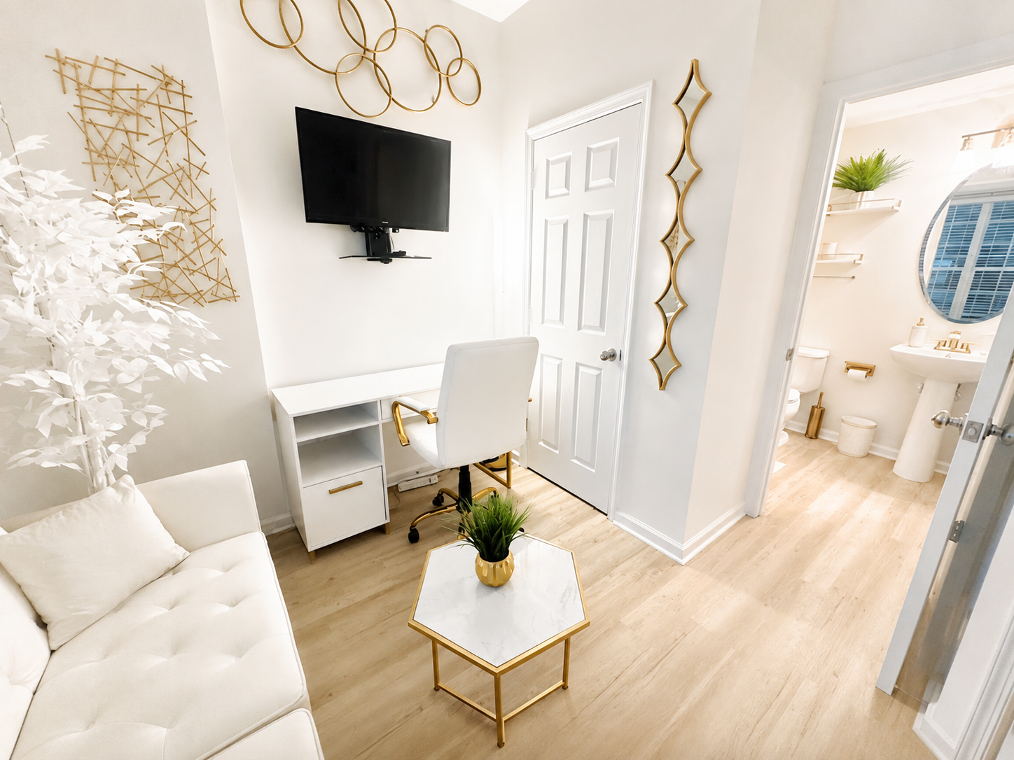 The Ashburn Residence — Dedicated office with white futon, desk, and attached bath visible through doorway