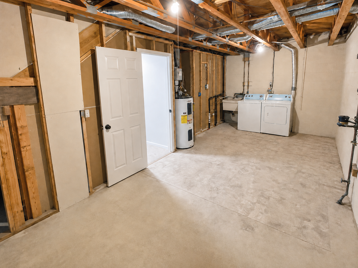 The Leeway Residence — Lower-level laundry area with washer, dryer, and storage space