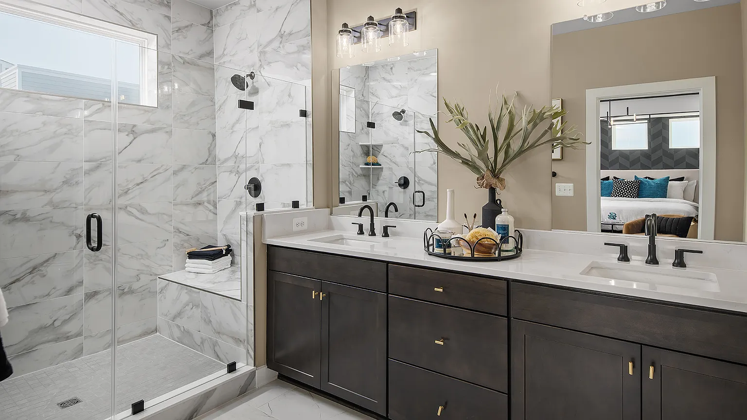 En suite bath with dual sink vanity, walk-in shower, and marble finishes at The Kincora Residence model home