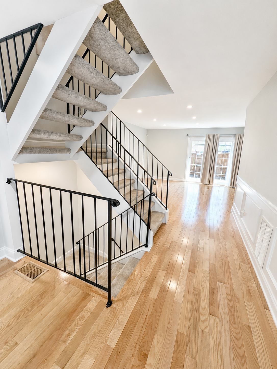 The Leeway Residence — Entryway with hardwood floors and open stairwell